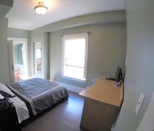 a bedroom with a bed and a desk and a window at Seattle Escape Queen Anne w Private Deck in Seattle