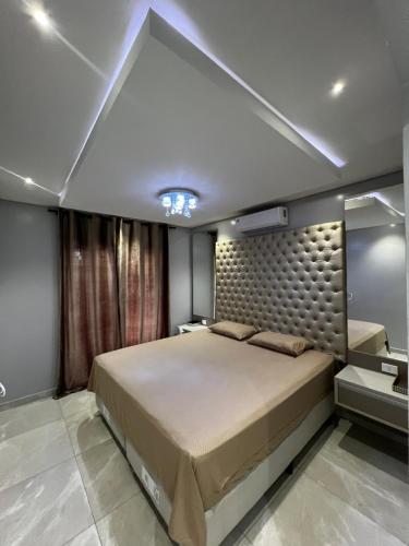 a bedroom with a large bed and a large mirror at Apartamento aconchegante com estacionamento privado in Salto del Guairá