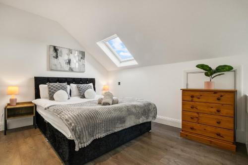 a bedroom with a bed and a dresser and a skylight at Bright & Glamorous Apartment 1BR 1BA Private Balcony in London