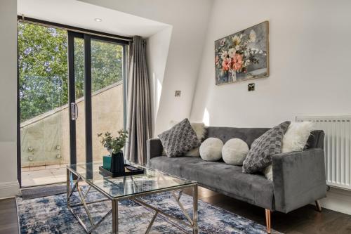 a living room with a couch and a glass table at Bright & Glamorous Apartment 1BR 1BA Private Balcony in London