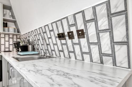 a kitchen with a marble counter top and a sink at Bright & Glamorous Apartment 1BR 1BA Private Balcony in London
