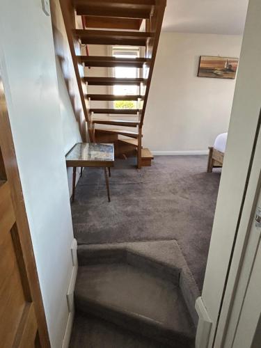 a view of a hallway with stairs and a table at Sea Views Studio in Dunedin