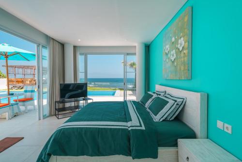a bedroom with a bed and a view of the ocean at Abian Kapas Beach House in Tabanan