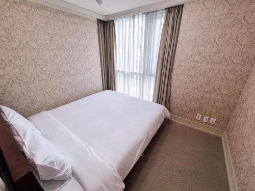 a small bedroom with a bed and a window at W Residence Hotel Centum City in Busan