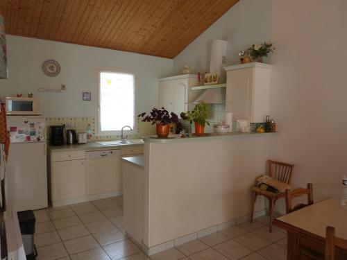 une cuisine avec des armoires blanches et un comptoir dans l'établissement Maison confortable à Barbâtre pour 6 pers., proche plage - FR-1-823-49, à Barbâtre
