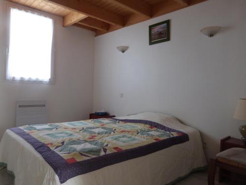 une chambre avec un lit avec une couette dessus dans l'établissement Maison confortable à Barbâtre pour 6 pers., proche plage - FR-1-823-49, à Barbâtre