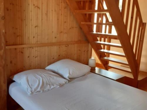 - un lit avec des draps blancs dans une chambre avec des escaliers dans l'établissement Maison 6 pers, proche plage, jardin & terrasse, WiFi, Noirmoutier - FR-1-823-63, à Barbâtre
