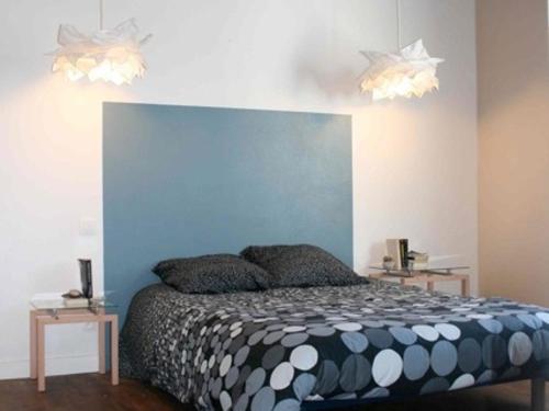 une chambre avec un lit avec une tête de lit bleue dans l'établissement Maison rénovée proche plage L'Herbaudière avec jardin et parking - FR-1-823-55, à Noirmoutier-en-l'lle