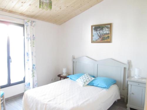 une chambre avec un lit blanc avec des oreillers bleus dans l'établissement Maison moderne à Noirmoutier, proche plage, 6 personnes - FR-1-823-58, à Noirmoutier-en-l'lle