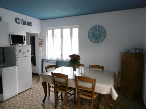 une cuisine avec une table avec des chaises et un réfrigérateur dans l'établissement Maison calme à Noirmoutier - 5 pers - Animaux - Parking - FR-1-823-68, à La Guérinière