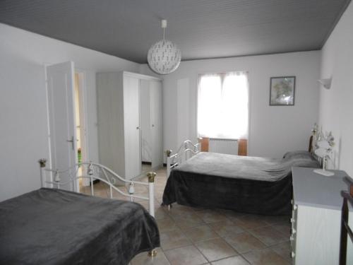 - une chambre avec 2 lits et une lampe pendant dans l'établissement Maison calme à Noirmoutier - 5 pers - Animaux - Parking - FR-1-823-68, à La Guérinière
