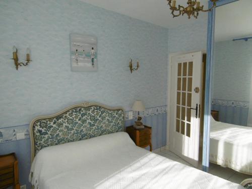 - une chambre avec un lit blanc et un mur bleu dans l'établissement Maison 8 personnes, proche plage, animaux admis, parking - FR-1-823-59, à Noirmoutier-en-l'lle