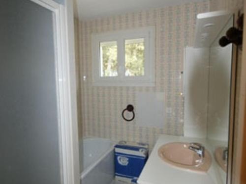 La salle de bains est pourvue d'un lavabo, d'une baignoire et d'une fenêtre. dans l'établissement Maison 8 personnes, proche plage, animaux admis, parking - FR-1-823-59, à Noirmoutier-en-l'lle