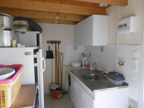 une petite cuisine avec un évier et un réfrigérateur dans l'établissement Maison 8 personnes, proche plage, animaux admis, parking - FR-1-823-59, à Noirmoutier-en-l'lle