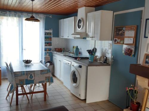 une cuisine avec une machine à laver et une table dans l'établissement Maison en bord de mer pour 6 pers avec WIFI et animaux admis - FR-1-823-67, à Barbâtre