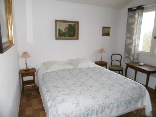 une chambre avec un lit et deux tables et une fenêtre dans l'établissement Maison de Bourg à Noirmoutier - 6 Pers, Secteur Calme, Parking, Animaux Admis - FR-1-823-82, à Noirmoutier-en-l'lle