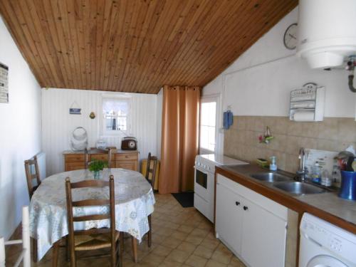 Il comprend une cuisine avec une table et un évier. dans l'établissement Maison 4/6 pers à Noirmoutier, proche port et plages - FR-1-823-85, à Noirmoutier-en-l'lle