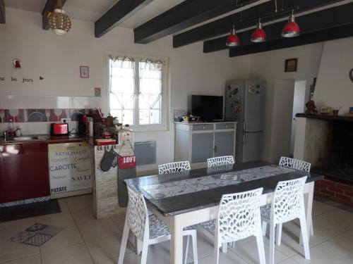 une cuisine avec une table et des chaises dans une pièce dans l'établissement Maison rénovée proche plage pour 5 personnes avec jardin à Barbâtre - FR-1-823-86, à Barbâtre