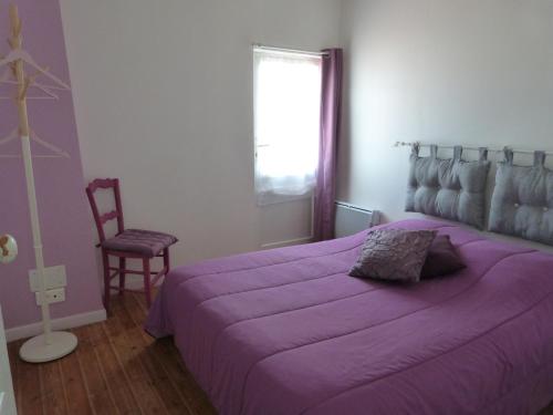 - une chambre avec un lit violet et une chaise dans l'établissement Maison rénovée proche plage pour 5 personnes avec jardin à Barbâtre - FR-1-823-86, à Barbâtre