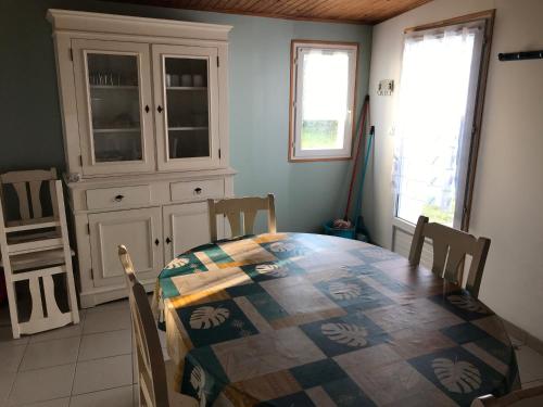 une salle à manger avec une table, des chaises et une armoire dans l'établissement Maison près des dunes, 5 min de la plage, Barbâtre - FR-1-823-79, à Barbâtre
