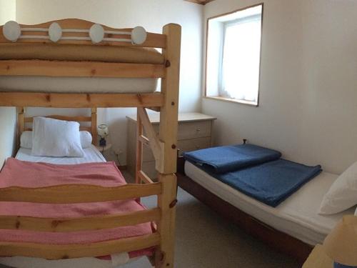 une chambre avec deux lits superposés et une fenêtre dans l'établissement Maison près des dunes, 5 min de la plage, Barbâtre - FR-1-823-79, à Barbâtre