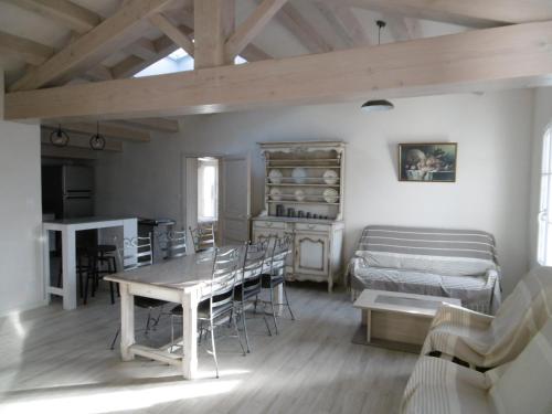 un salon avec une table et un lit dans l'établissement Maison rénovée 2019 proche plage avec jardin privé - FR-1-823-89, à LʼÉpine