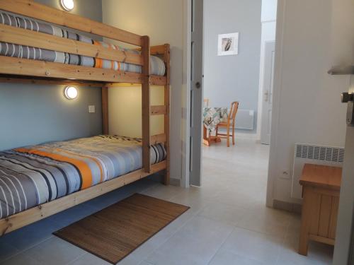 - une chambre avec 2 lits superposés et une salle à manger dans l'établissement Maison mitoyenne à Barbâtre, proche plage, 4 personnes, Wi-Fi, jardin clos - FR-1-823-92, à Barbâtre