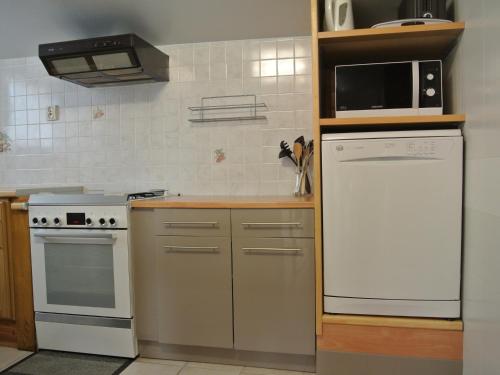 La cuisine est équipée d'un réfrigérateur blanc et d'un four micro-ondes. dans l'établissement Maison confortable 3 chambres proche plage à Noirmoutier - FR-1-823-95, à Barbâtre