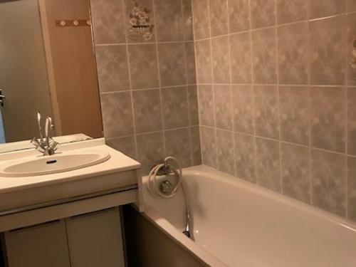 La salle de bains est pourvue d'un lavabo et d'une baignoire à côté d'un lavabo. dans l'établissement Maisonnette à 30m de la plage pour 4 pers - Barbâtre - FR-1-823-96, à Barbâtre