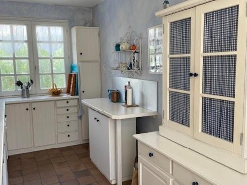 une cuisine avec des placards blancs et un comptoir blanc dans l'établissement Maison confortable pour 8 pers. à Barbâtre, près de la plage - FR-1-823-97, à Barbâtre
