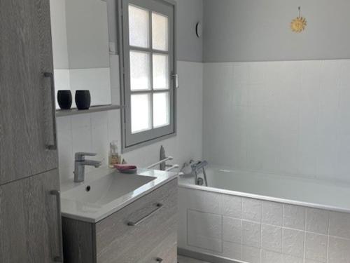 une salle de bain avec un lavabo, un miroir et une baignoire dans l'établissement Maison confortable pour 8 pers. à Barbâtre, près de la plage - FR-1-823-97, à Barbâtre