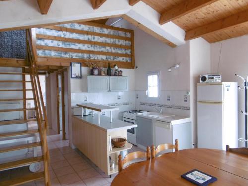 une cuisine avec des appareils blancs et un plafond en bois dans l'établissement Maison à Noirmoutier - Proche Plage - Parking - FR-1-823-98, à Noirmoutier-en-l'lle