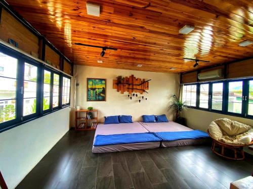 a bedroom with a large bed in a room with windows at roc rach homestay in Ấp Tân Hà