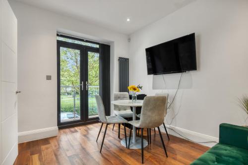 a living room with a table and chairs and a tv at Unique Stylish Duplex 2BR 2BA Balcony in London
