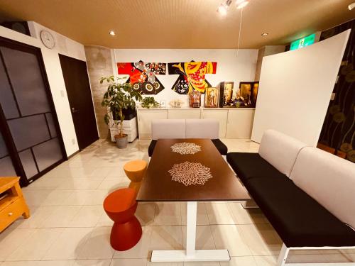 a living room with a table and a couch at --New--南町駅徒歩1分-ビル2階-貸切ルーム8人まで-松山城や道後温泉へアクセス良好-駐車場無料 in Matsuyama