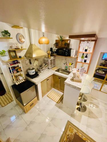 Una pequeña cocina con fregadero y estufa. en Binangonan Primes Tiny Home with FREE breakfast, en Binangonan