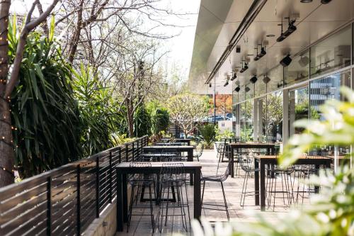 a row of tables and chairs outside of a building at Hotel TOTTO Wollongong in Wollongong