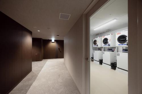 a hallway with washers and dryers in a building at Minn STATION Ai Nagoya in Aoichō