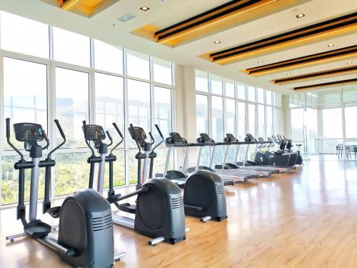 a gym with rows of tread machines and large windows at Windmill Upon Hills Genting Highland in Genting Highlands