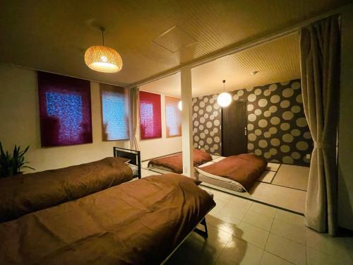 a bedroom with two beds in a room at --New--南町駅徒歩1分-ビル2階-貸切ルーム8人まで-松山城や道後温泉へアクセス良好-駐車場無料 in Matsuyama