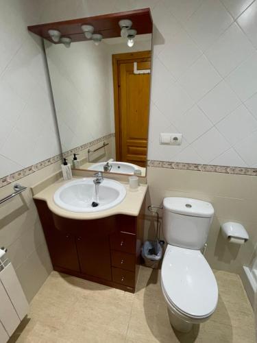 a bathroom with a toilet and a sink and a mirror at EVA & TRAVEL - CAL MARCEL - Habitacion in Prades