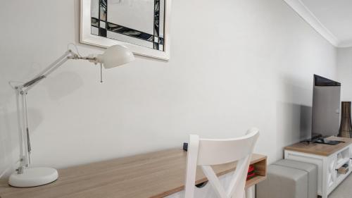 a white desk with a white chair and a lamp at Umina Beach Coastal Getaway in Umina Beach 