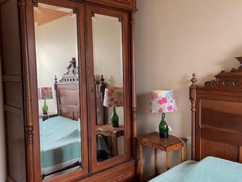 - une chambre avec un grand miroir à côté d'un lit dans l'établissement Maison 4 pers à Barbâtre près plage, wifi, parking - FR-1-823-102, à Barbâtre