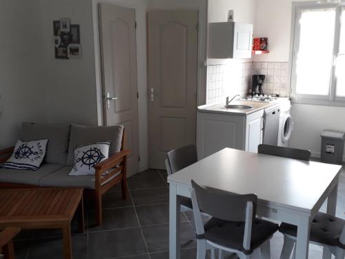 une cuisine et un salon avec un canapé et une table dans l'établissement Maison Noirmoutier 6 pers proche plage, animaux OK - FR-1-823-107, à Barbâtre