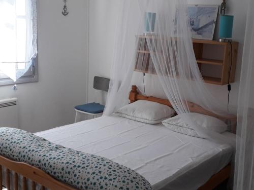 - une chambre avec un lit avec un filet dans l'établissement Maison Noirmoutier 6 pers proche plage, animaux OK - FR-1-823-107, à Barbâtre