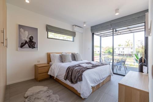 チェンマイにあるBlubamboo162 3 Bedroom Tranquil Pool Villaの大きなベッドとバルコニーのある寝室