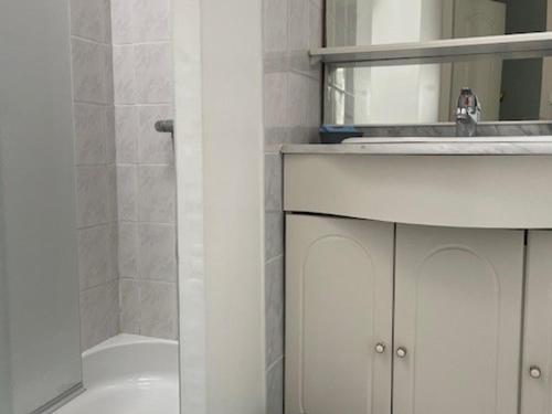 une salle de bain avec un lavabo, un miroir et une baignoire dans l'établissement Maison mitoyenne proche plage, centre Barbâtre, pour 4 personnes - FR-1-823-109, à Barbâtre