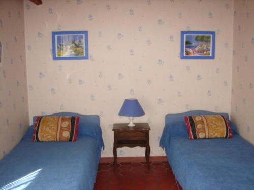 deux lits dans une chambre avec une lampe sur une table dans l'établissement Maison confortable à 300 m de la plage, animaux acceptés - FR-1-823-113, à La Guérinière