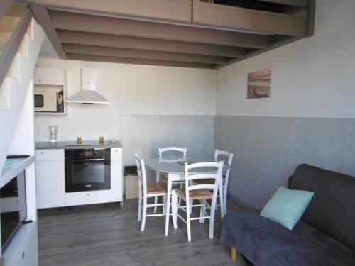 a kitchen and a living room with a table and chairs at Charmante maisonnette proche plage - Animaux admis - FR-1-823-117 in Barbâtre
