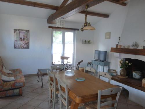 une salle à manger avec une table et des chaises en bois dans l'établissement Maison à Barbâtre, accès direct plage, animaux admis - FR-1-823-120, à Barbâtre